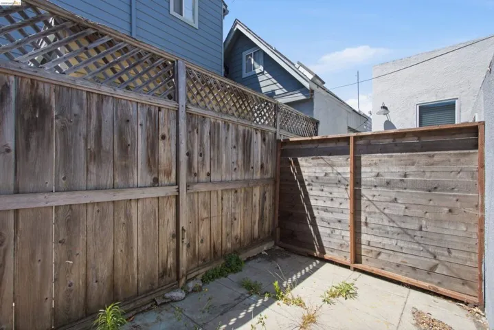 Enclosed outdoor space featuring a wood plank fence with lattice detailing, a horizontal wood slat fence, and a concrete patio surface