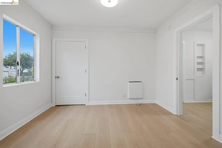 Bright interior space featuring light wood-finish flooring, white walls, and a recessed ceiling light fixture