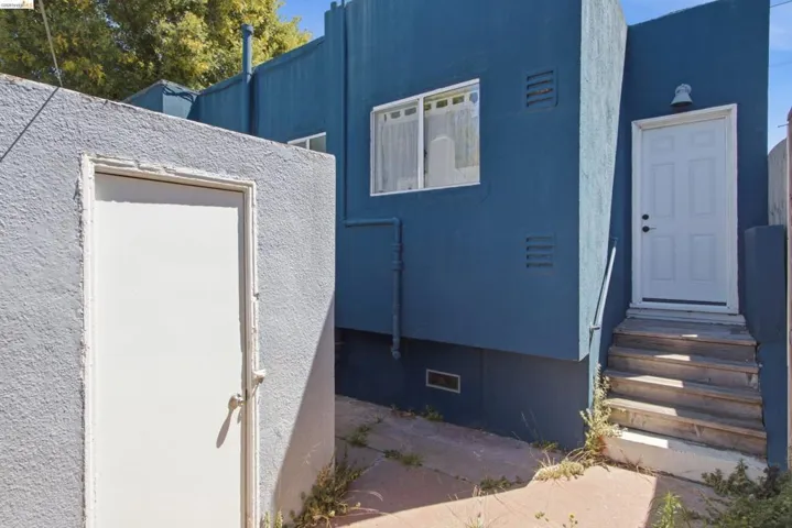 Exterior stucco finish in a rich blue hue with white trim