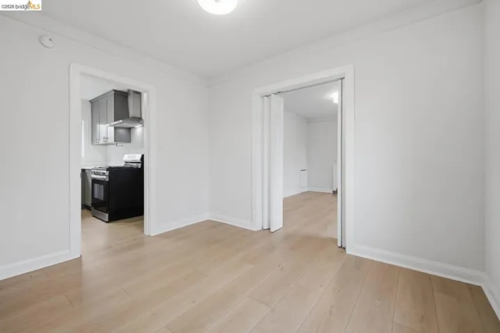 Bright interior space featuring light wood-finish flooring, white walls, and crown molding