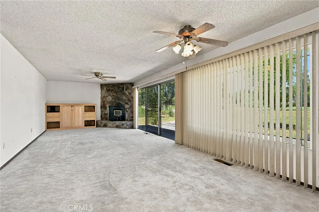 Large living and dining area is all windows looking toward the backyard.