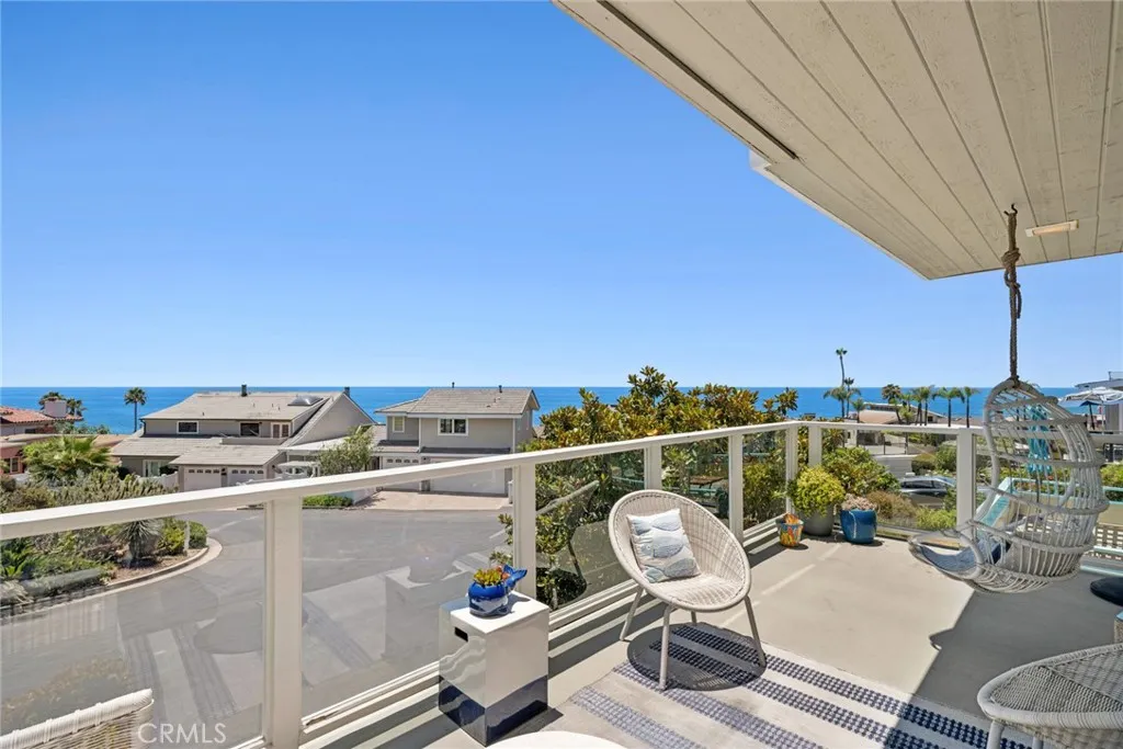 Complete with a wet bar, beverage refrigerator, and French doors opening to an ocean view deck, this inviting space embraces indoor outdoor living while capturing panoramic coastal vistas.