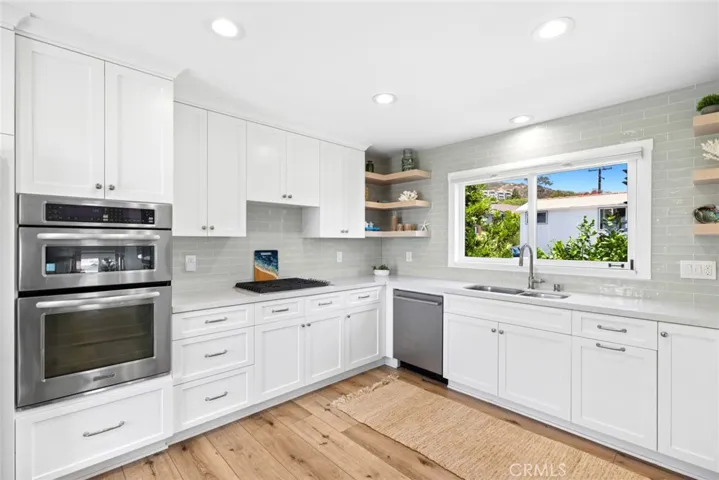  Appointed with stainless steel appliances, quartz countertops, a subway tile backsplash, and a pantry with pull-out shelving, the kitchen blends style with functionality.