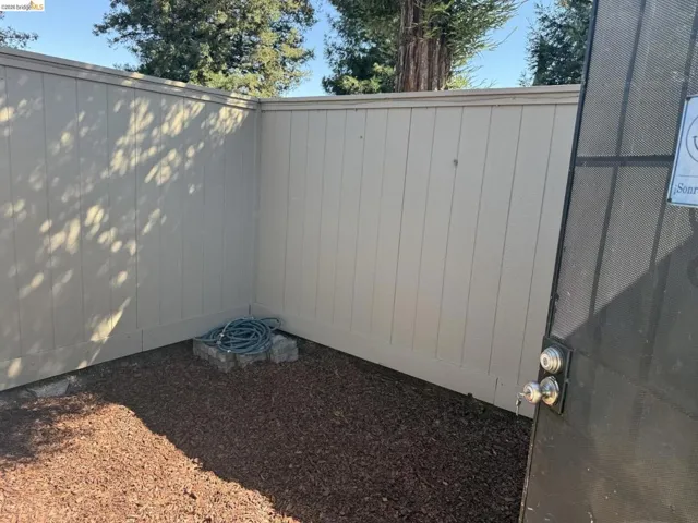 Private outdoor area featuring a corner privacy fence with vertical panels