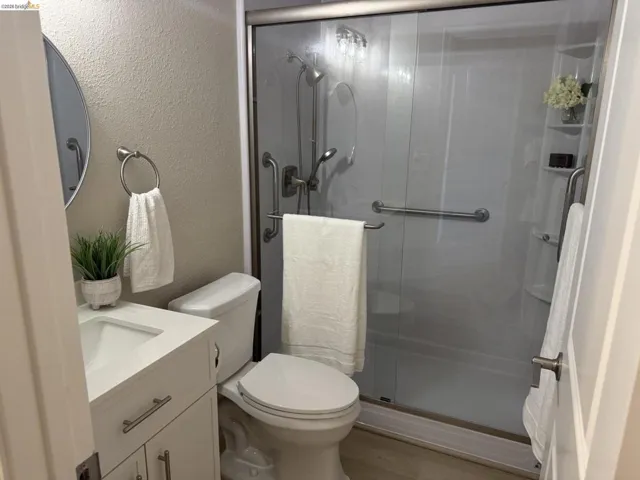 White vanity with shaker-style cabinetry, an integrated sink, and modern brushed nickel hardware