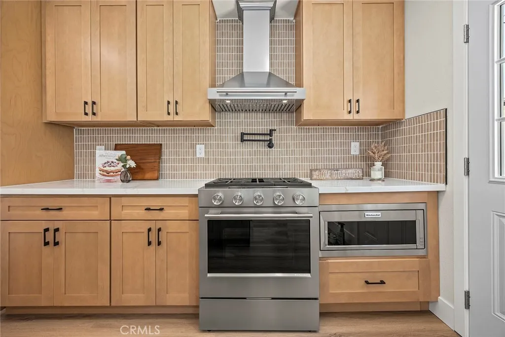 ZLINE professional range hood, pot filler, and matte porcelain backsplash