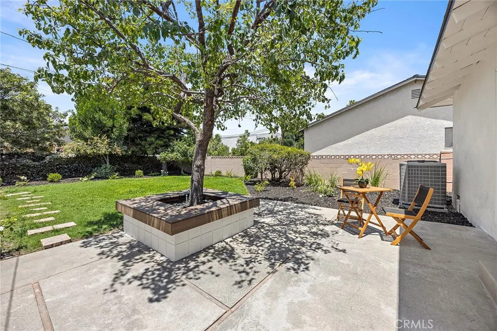 Vinyl decking and seating area surrounding the masonry planter — a charming spot to relax beneath the shade tree