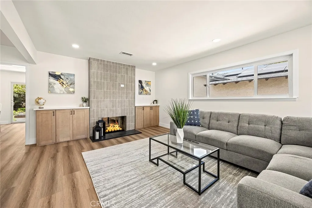 Open flow from the living room into the updated kitchen, connected by the dual-sided fireplace