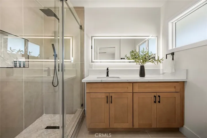 Beautifully updated ensuite with large-format porcelain tile, marble shower flooring, quartz counters, and a new vanity