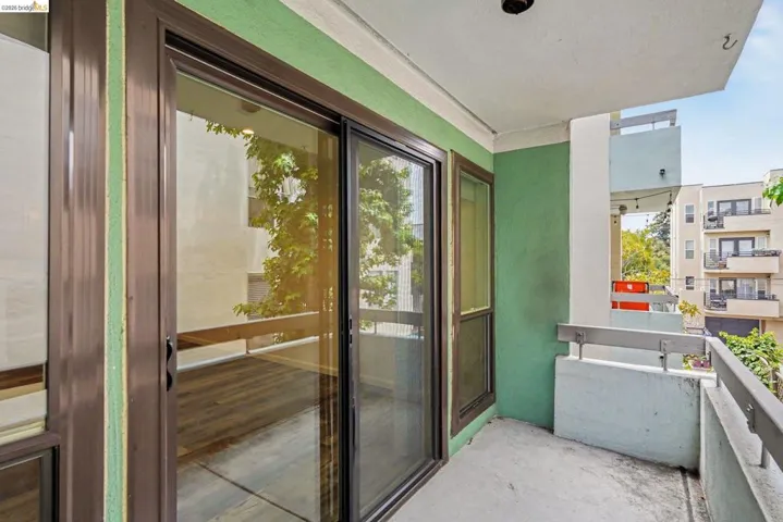 Private balcony featuring a concrete floor, painted concrete railing, and a sliding glass door with a dark frame