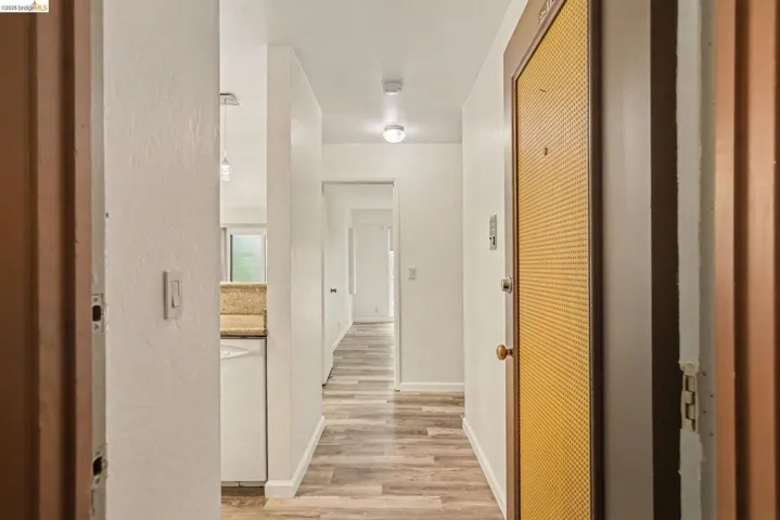 Entrance hallway featuring wood-finish flooring, white walls, and recessed lighting
