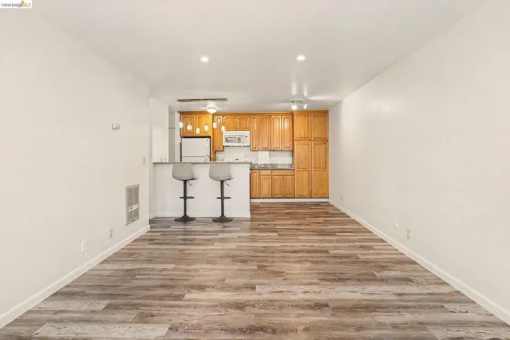 Open-concept living space featuring wood-finish flooring, recessed lighting, and a neutral color palette