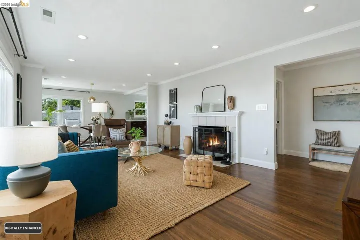 Living area featuring rich wood-finish flooring, recessed lighting, and a tiled fireplace with a classic mantel