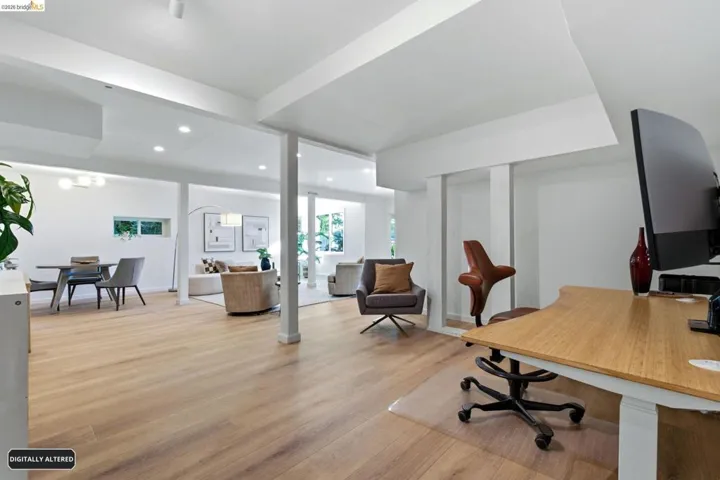 Open-concept lower level featuring recessed lighting, light wood-finish flooring, white walls, and structural columns