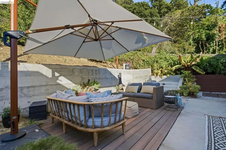 Decked patio featuring a slatted wood surface and concrete retaining walls