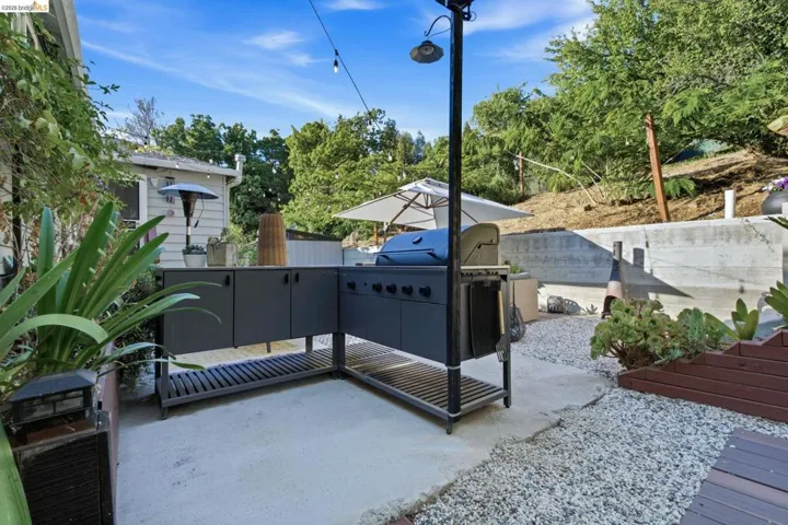 Outdoor kitchen featuring a built-in grill and dark cabinetry