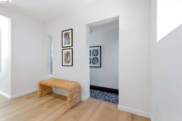 Light wood-finish flooring extending into a bright hallway