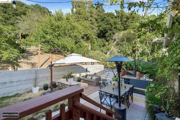 Terraced outdoor yard-  backyard space features a wood deck, concrete patio, and mature landscaping making outdoor entertaining easy.