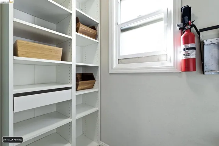 Built-in white shelving system featuring adjustable shelves and a single drawer