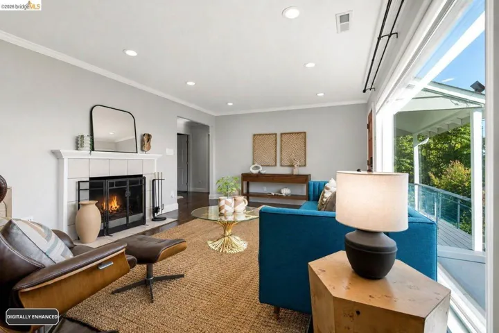 Living area featuring a tiled  wood burning fireplace with a metal screen, recessed lighting, wood-finish flooring, and crown molding