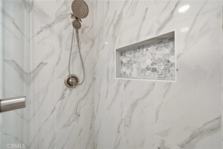 Luxury step-in shower with barn door style glass enclosure.