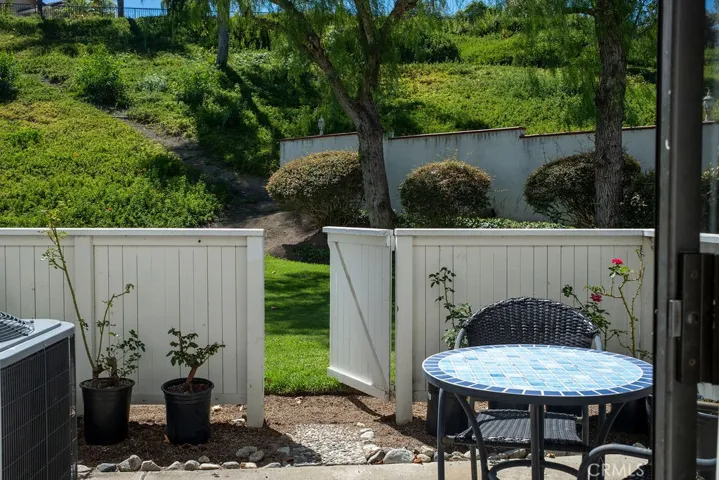 Patio view showing exit gate to greenbelt and landscaping.
