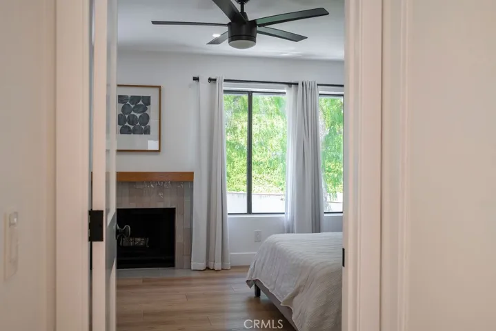 Entrance to primary bedroom showing greenbelt view and updated fireplace.
