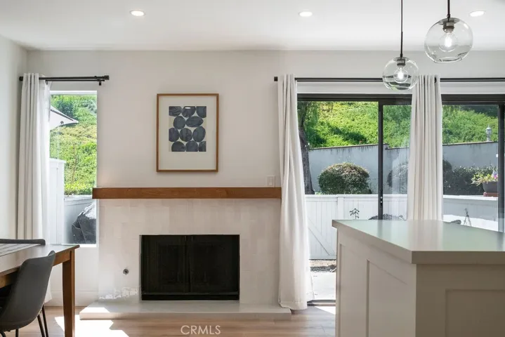 View of sunny family kitchen with updated fireplace and island