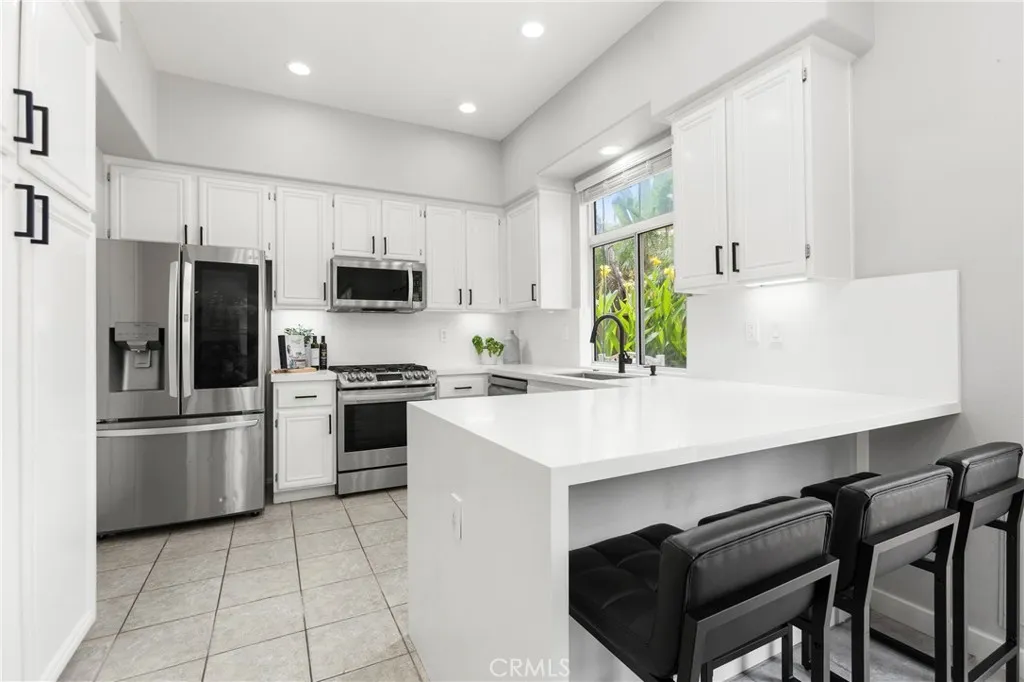 White cabinetry, led lighting, waterfall quartz breakfast bar