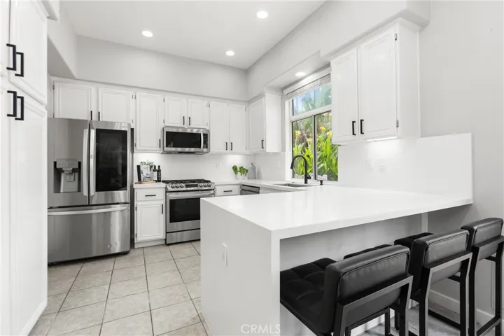 White cabinetry, led lighting, waterfall quartz breakfast bar