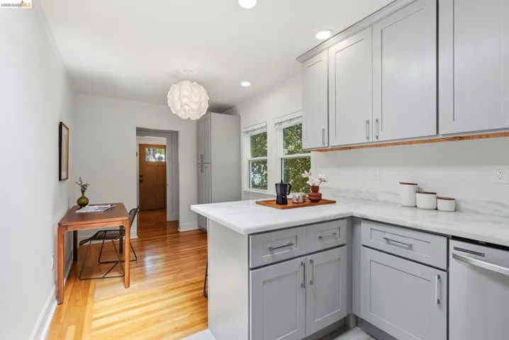 Kitchen area featuring light gray cabinetry, white countertops, stainless-steel appliances, recessed lighting, and wood-finish flooring