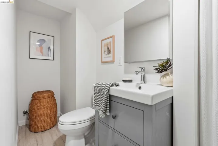Bathroom featuring a contemporary vanity with an integrated white sink, chrome faucet, and mirrored medicine cabinet