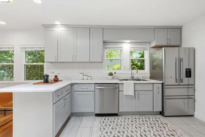 Kitchen featuring light gray cabinetry, white countertops, stainless steel appliances, and recessed lighting