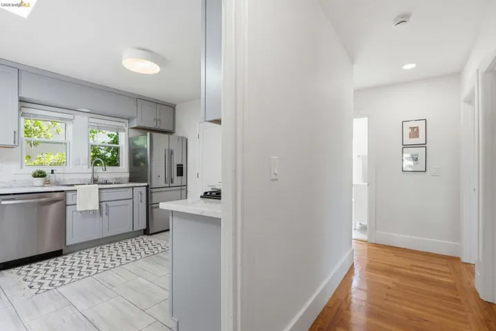 Modern kitchen featuring stainless steel appliances, light gray cabinetry, and white countertops