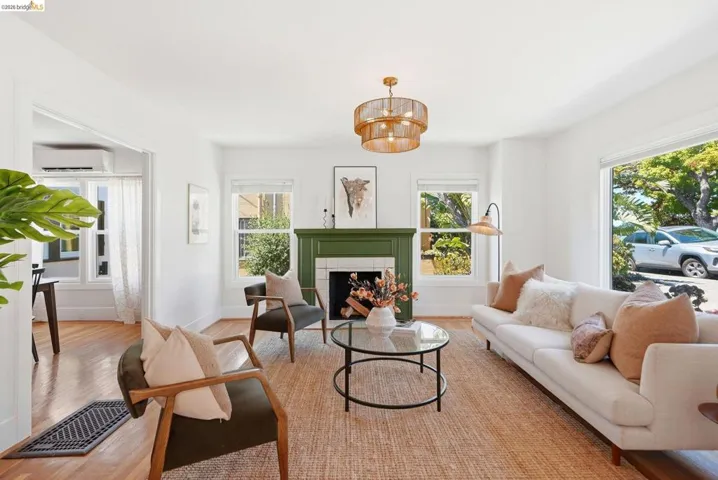 Hardwood-style flooring throughout the living area, featuring a decorative fireplace with a painted green mantel and white tile surround