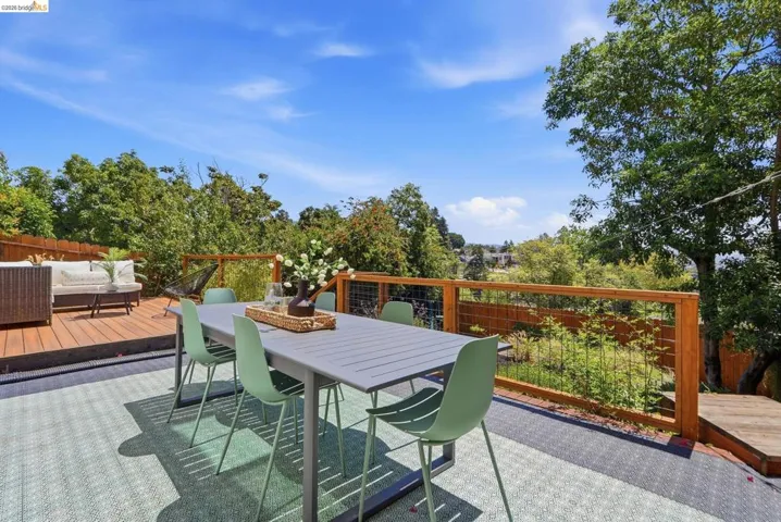 Expansive outdoor deck featuring wood decking, a cable railing system, and a distinct patterned outdoor rug