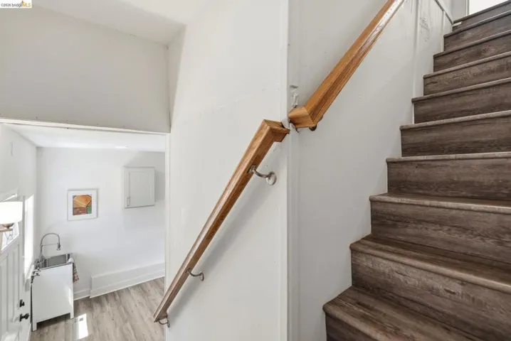 Staircase with wood-finish treads and risers, complemented by a natural wood handrail