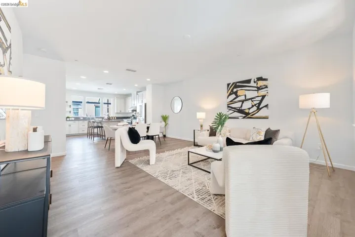 Open-concept living space featuring wood-finish flooring, recessed lighting, and white walls