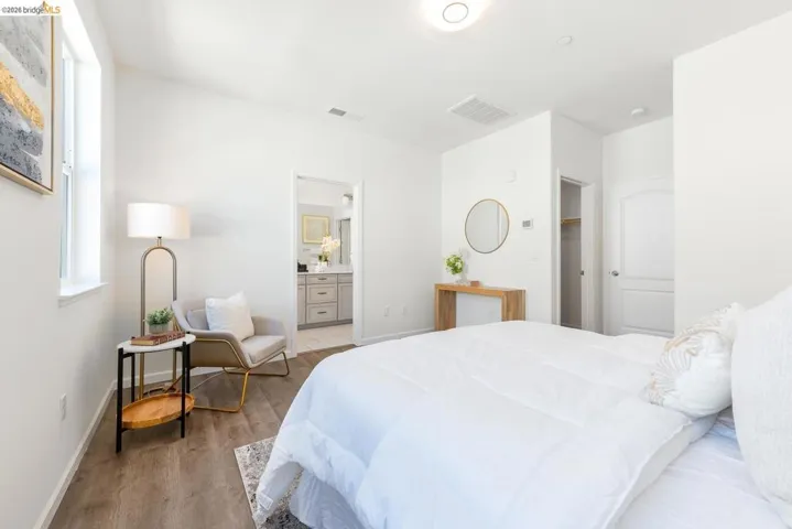 Bedroom featuring wood-finish flooring and a window with white trim
