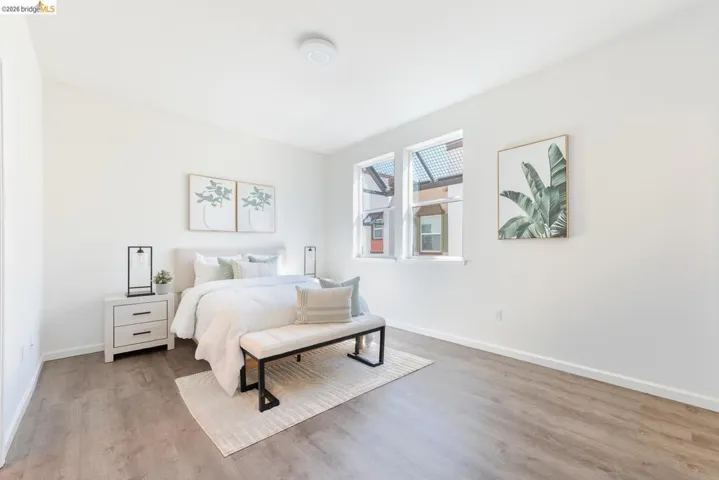 Bright interior space featuring light-toned walls, wood-finish flooring, and multiple windows