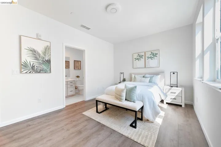 Bedroom featuring wood-finish flooring, white walls, and bright windows