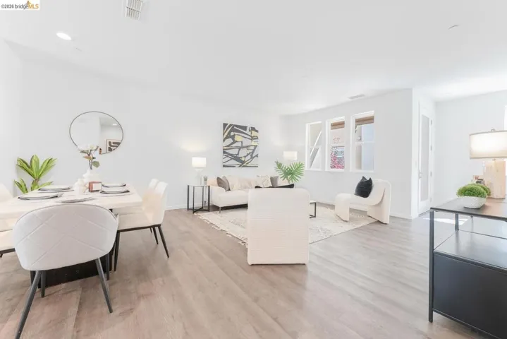 Open-concept living space featuring wood-finish flooring, recessed lighting, and white walls