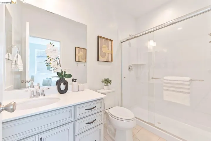 Bathroom featuring a single vanity with stone countertop, undermount sink, and brushed nickel faucet