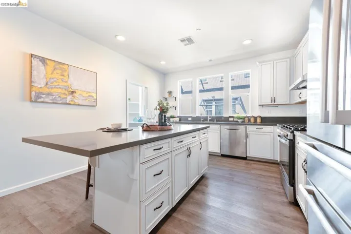 Modern kitchen with a central island featuring a grey countertop and white cabinetry