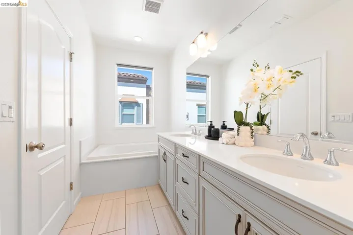 Double vanity featuring light-toned cabinetry, undermount sinks, and polished chrome fixtures