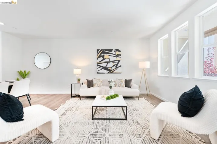 Bright living space featuring wood-finish flooring and multiple windows