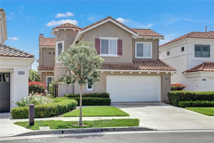 A distinctive front elevation showcases timeless coastal architecture with a charming turret, manicured landscaping, and an oversized two-car garage, creating exceptional curb appeal from the moment you arrive.