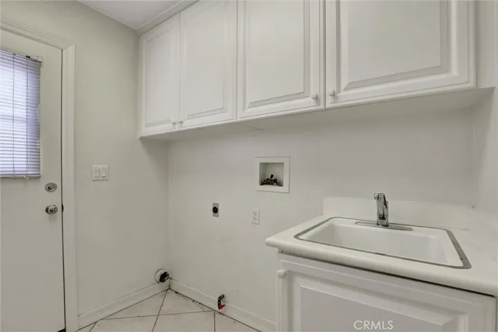 The separate interior laundry room offers built-in cabinetry along with both gas and electric dryer hookups for added flexibility.