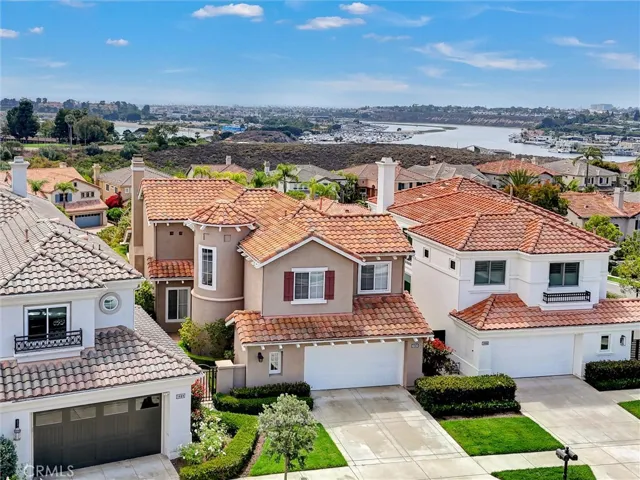 An elevated aerial view highlights the home's commanding position above Newport Back Bay, where coastal, bay, and city light views create an exceptional backdrop to this elegant Newport Beach residence.