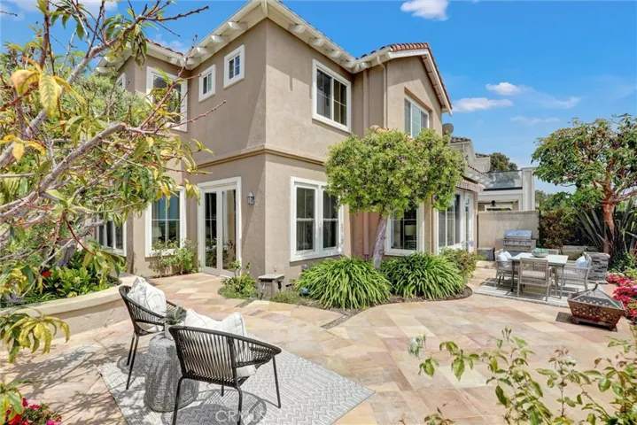 The expansive backyard patio offers multiple areas for relaxing and entertaining while enjoying beautiful views of the Upper Newport Bay and Pacific Ocean beyond.